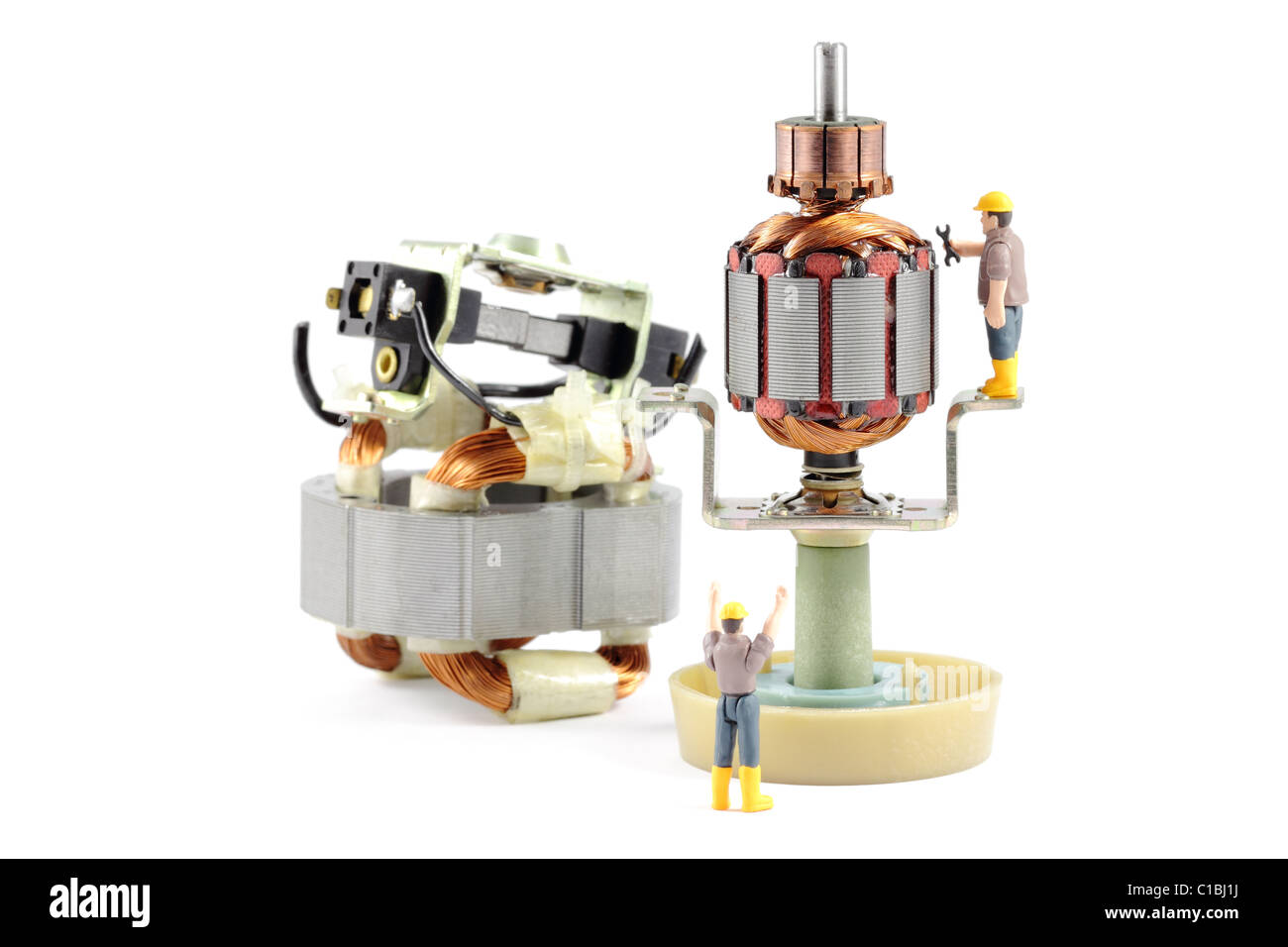 Elektromotor Reparatur - Makroaufnahme eines zerlegten Elektromotors gearbeitet wird von zwei kleinen Spielzeug-Ingenieuren, Konzept. Stockfoto
