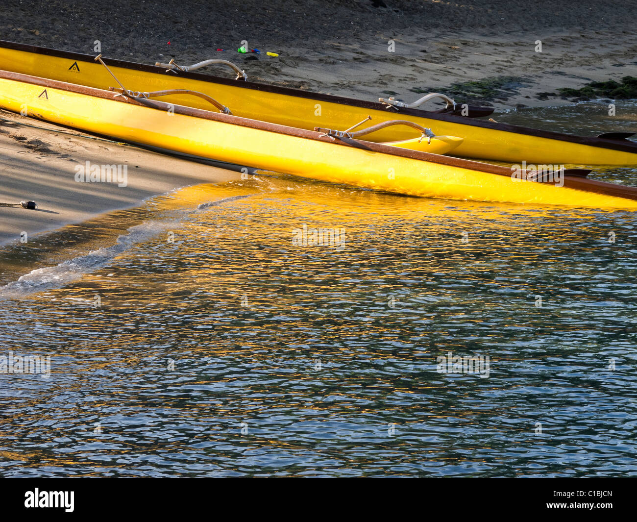 Ein Ausleger-Kanu direkt am Meer in der Kahuwai Bay in Kona, Hawaii. Stockfoto