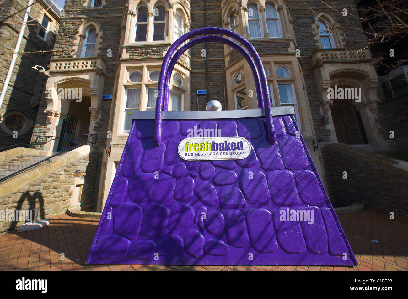 Enormen Werbe lila Handtasche außerhalb Niederlassungen eines Unternehmens-Support-Gruppe in Cardiff South Wales UK Stockfoto