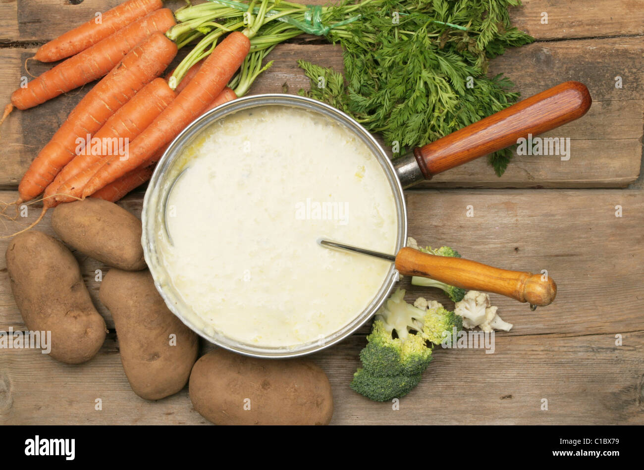 Topf mit Suppe, umgeben von frischem Gemüse Stockfoto