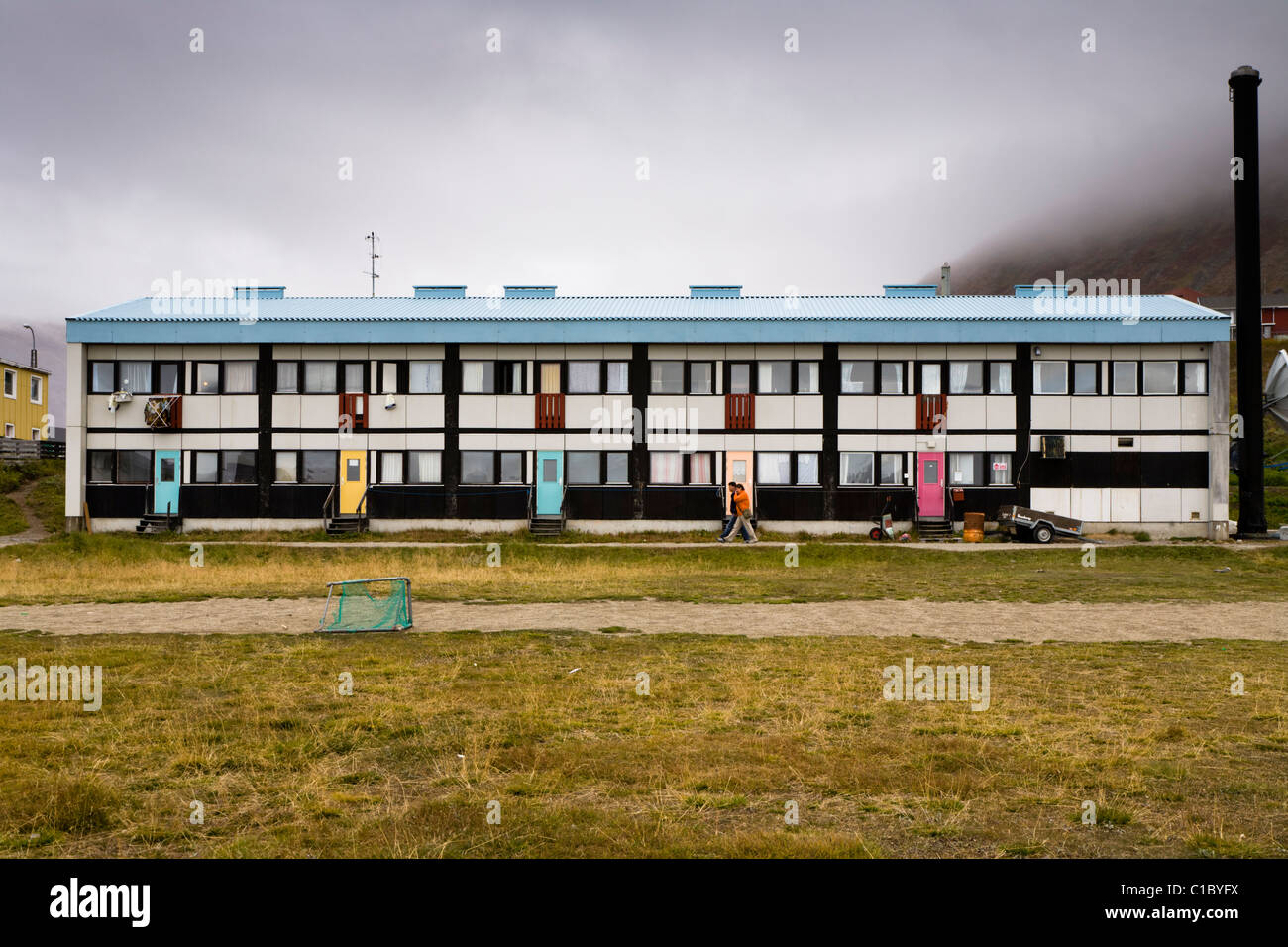 Menschen zu Fuß vorbei an Wohnungen, Narsaq, Süd-Grönland. Stockfoto