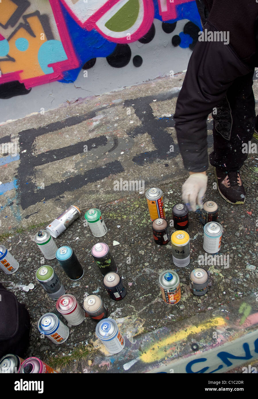 Graffiti-Künstler bei der Arbeit mit Sprühfarbe Dosen Stockfoto