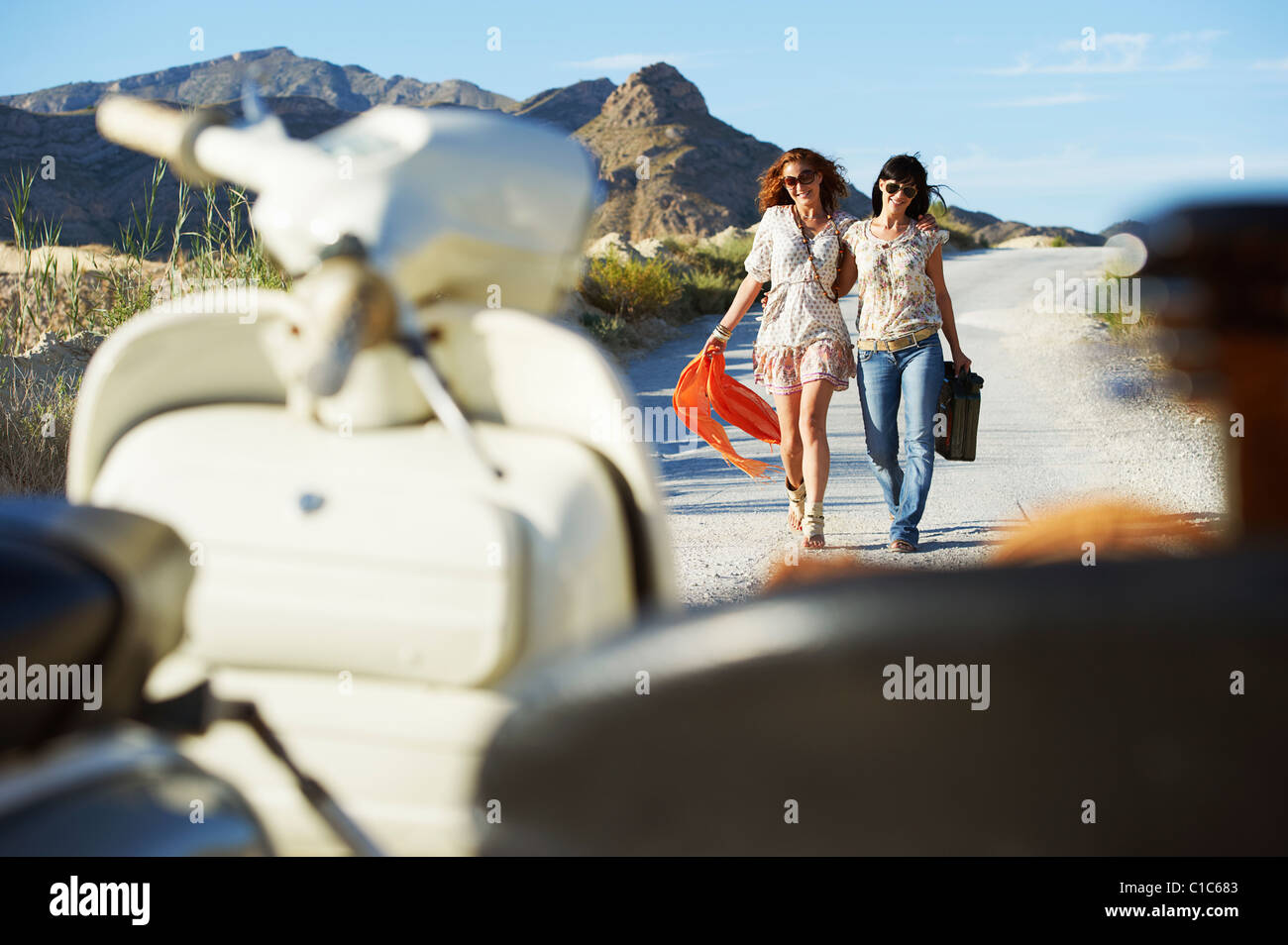 Frauen, die zu Fuß in Richtung Motorrad Stockfoto