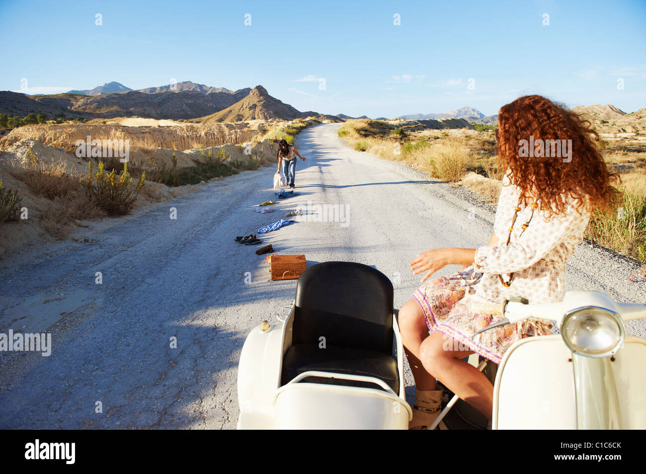 Frau, die Kleidung von der Straße aufnehmen Stockfoto