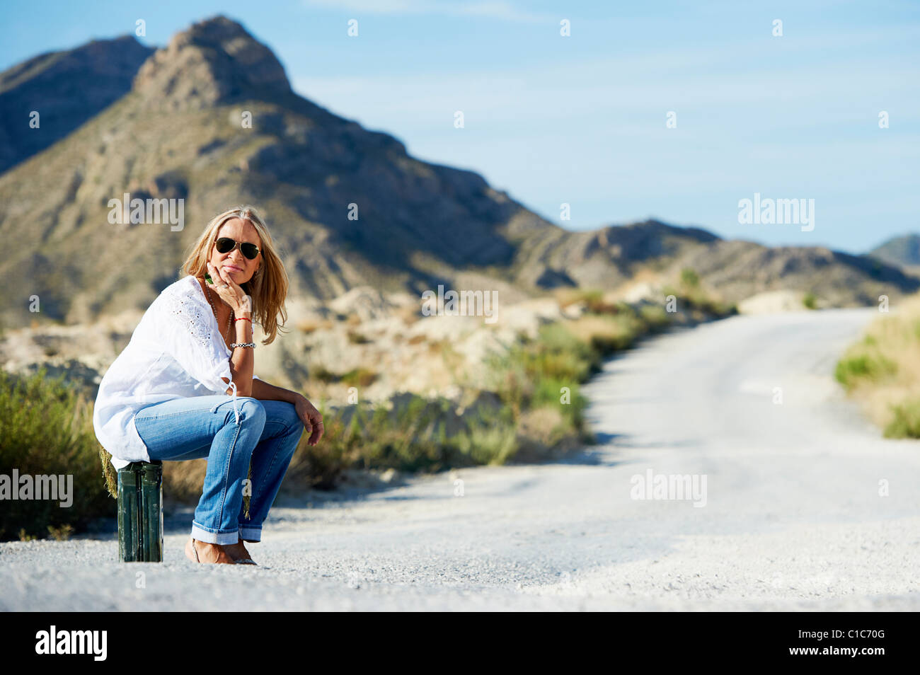 Frau sitzt auf Benzin kann in der Straße Stockfoto