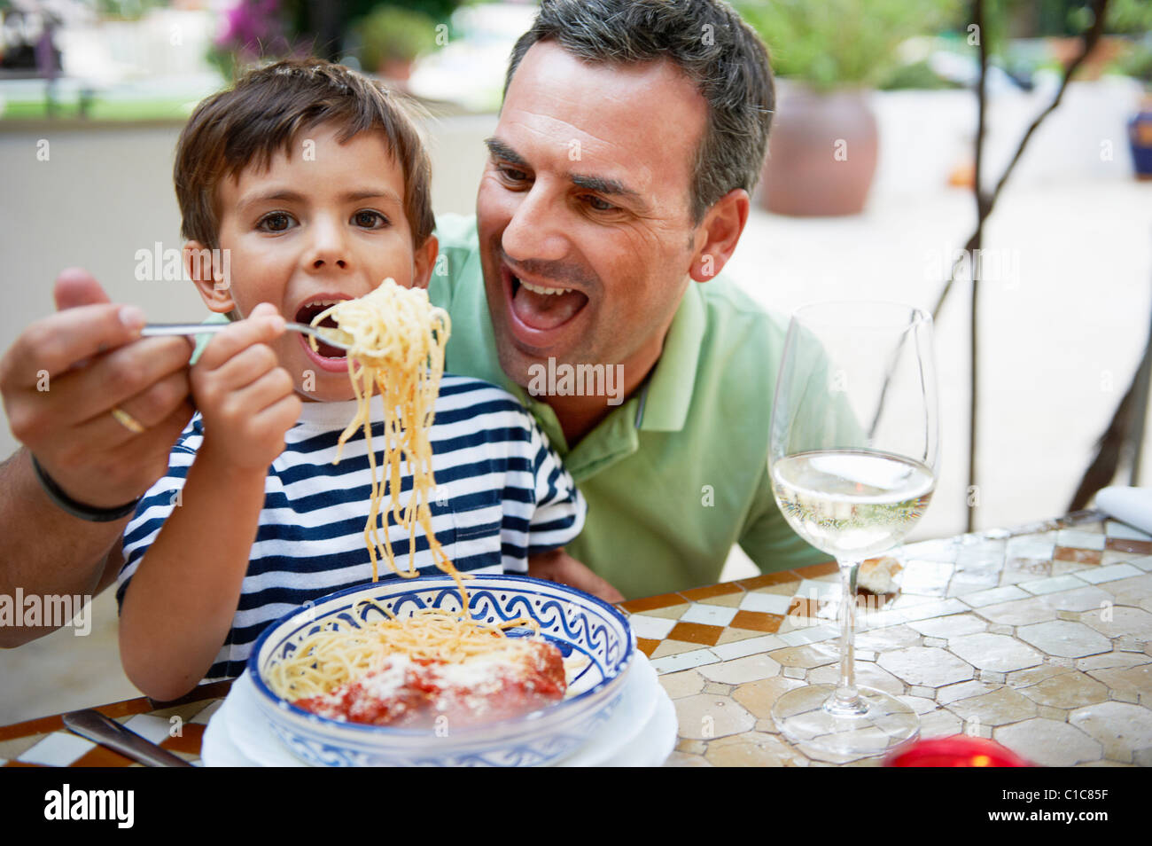 Vater und Sohn Spaghetti-Essen Stockfoto
