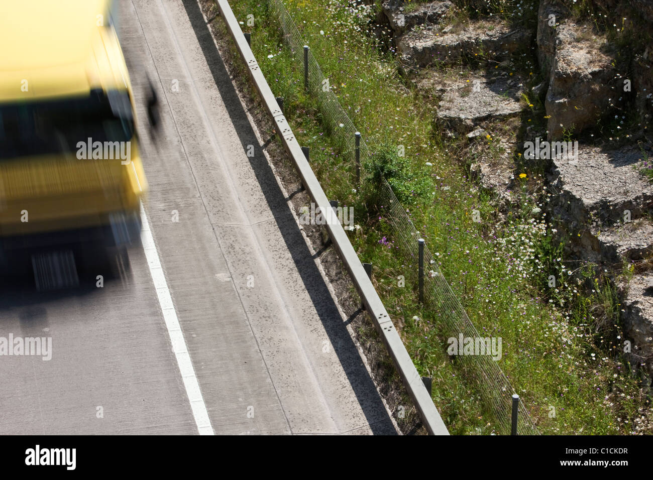 Nahaufnahme eines gelben Lkws auf der zweispurigen A417 nördlich von Cirencester in den Cotswolds mit Geschwindigkeit bewegen. Stockfoto