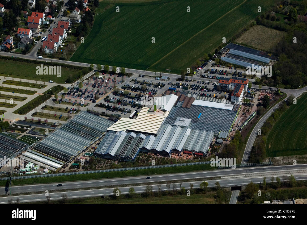 Luftaufnahme über Kindergarten Gewächshäuser neben Autobahn bayerische Landschaft Deutschland Stockfoto