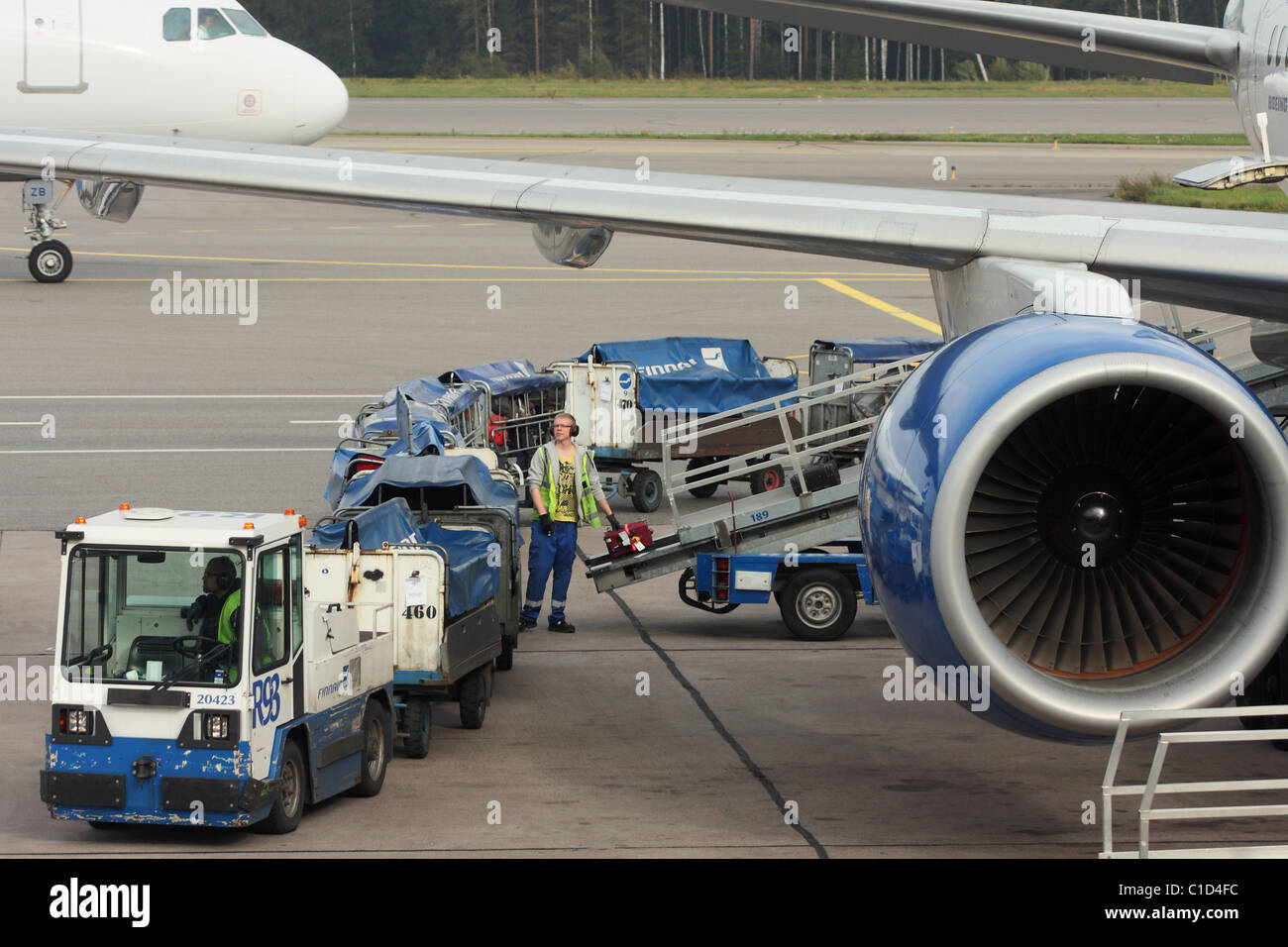Die Mitarbeiter des Flughafens bringt einen Koffer auf einem Förderband-Band. Finnair. Flughafen Helsinki, Vantaa, Finnland Stockfoto