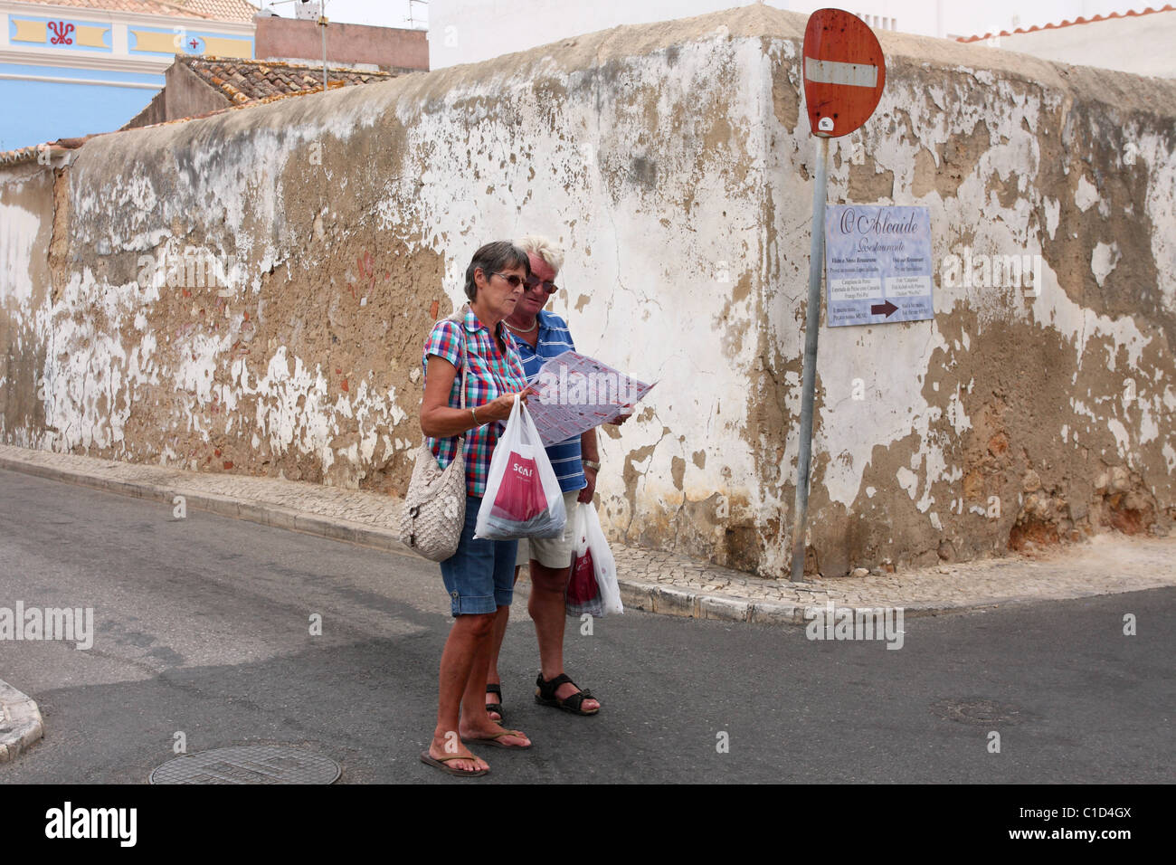 Zwei Touristen schauen Sie sich die Karte an einem Scheideweg. Alvor, Algarve, PORTUGAL Stockfoto