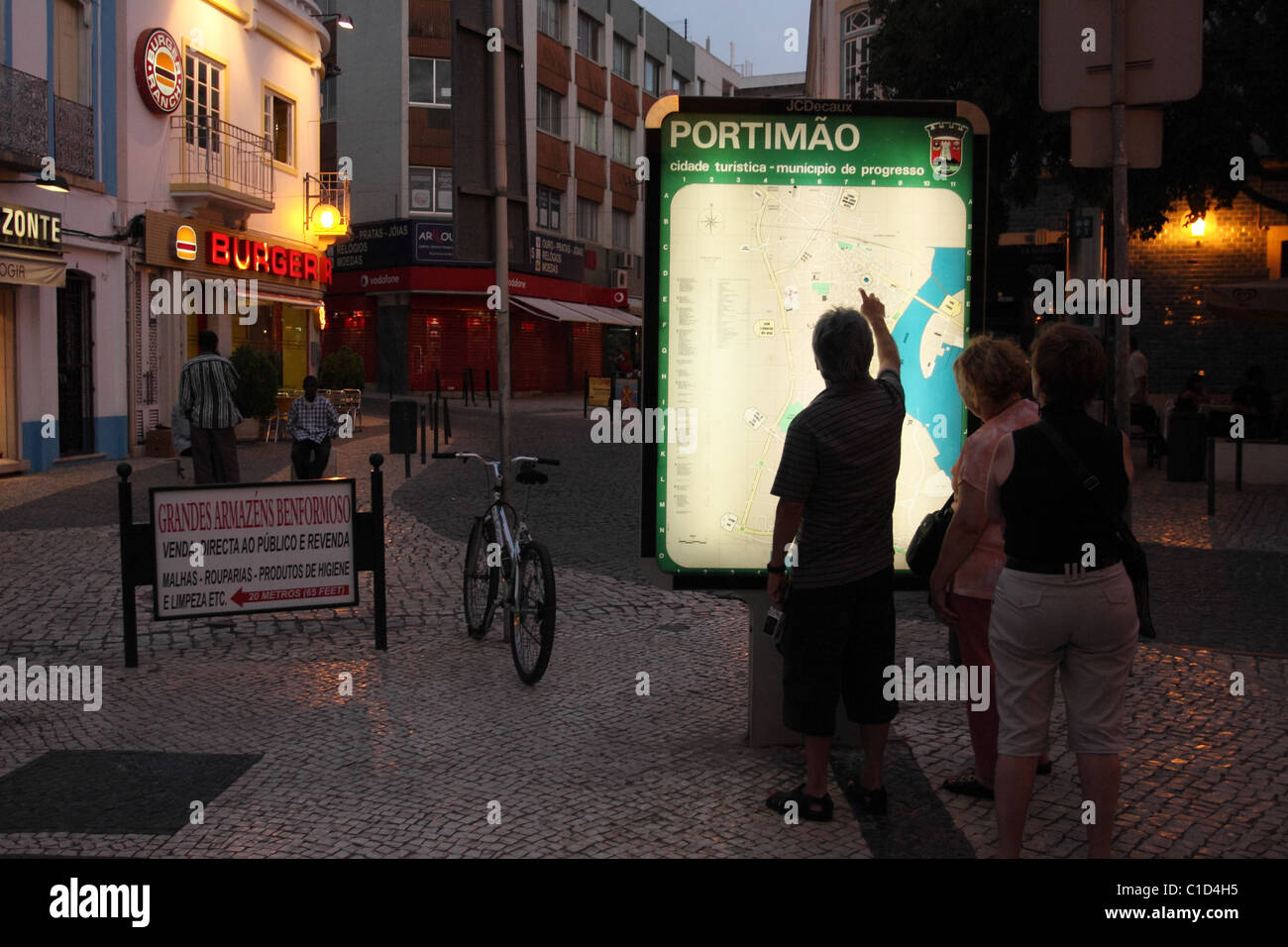 Touristen suchen sich eine Karte von der Stadt Portimao in den späten Abend. Portimao, Algarve, PORTUGAL Stockfoto