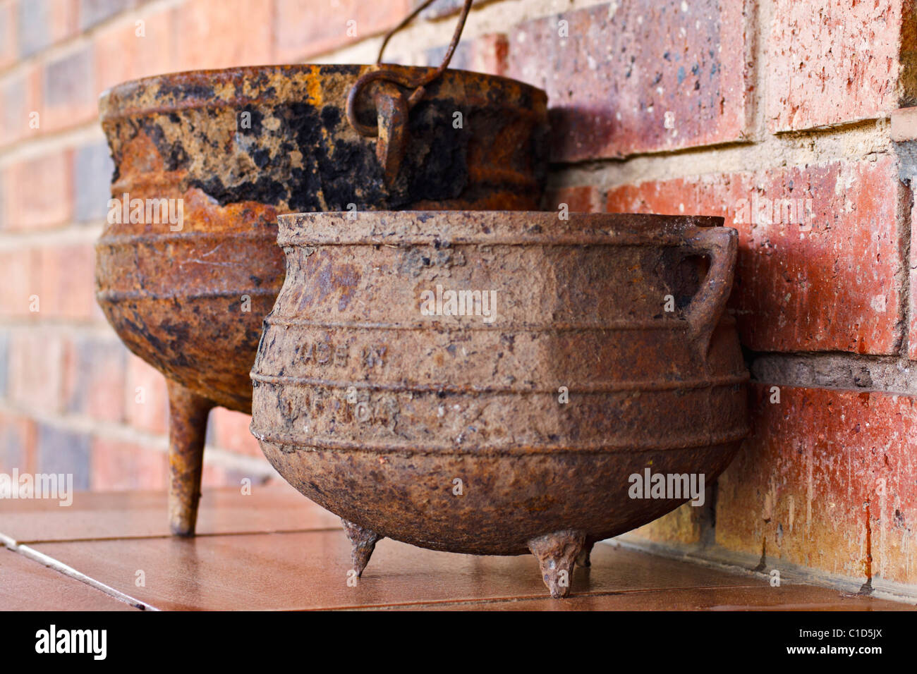Traditionelle Gusseisen dreibeinige Kochtöpfe aus Südafrika, Phutu von indigenen Stämmen und Potjie von Buren genannt. Stockfoto
