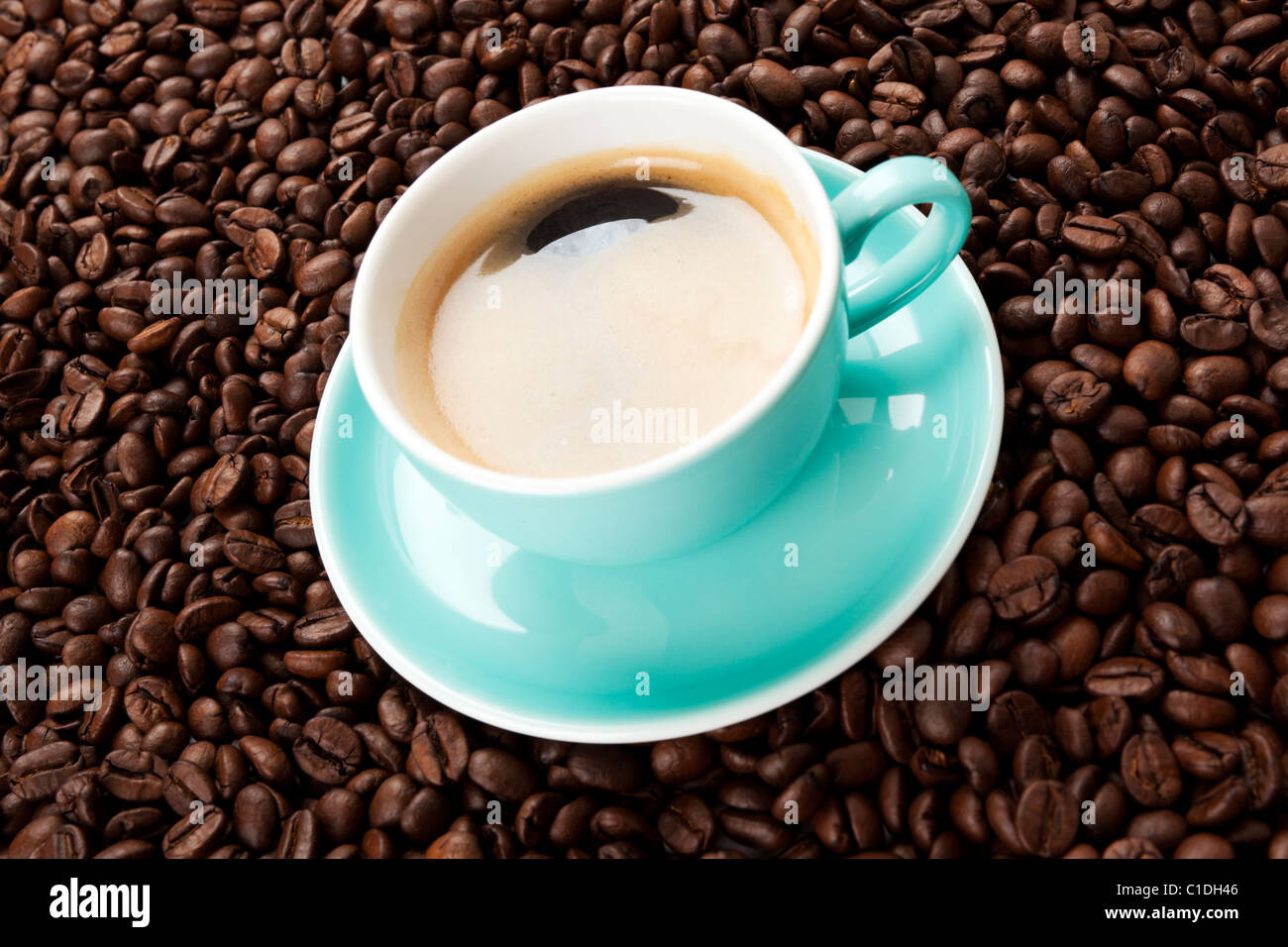Türkis Espressotasse auf Kaffeebohnen Stockfoto