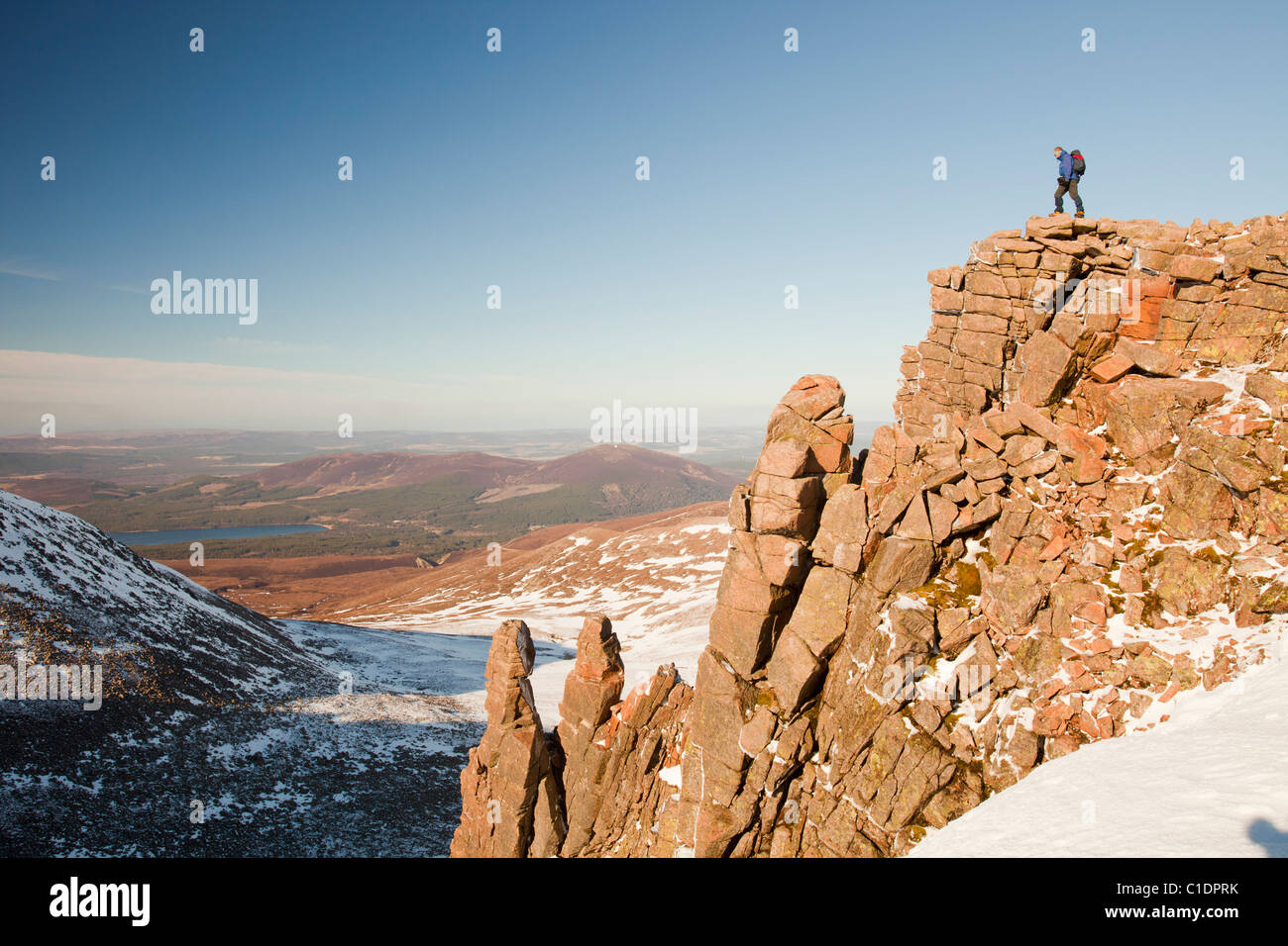 Ein Bergsteiger auf einem felsigen Granit Felsvorsprung oberhalb Coire eine Lochain in Cairngorm Mountains, Schottland, Großbritannien. Stockfoto