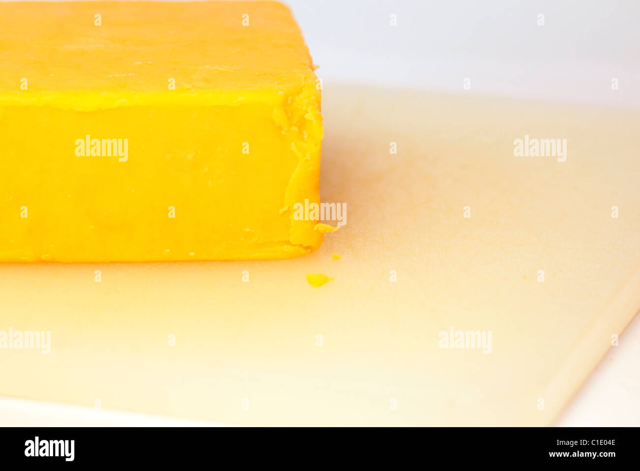 Block von Colby Cheddar-Käse auf ein Schneidebrett Stockfoto