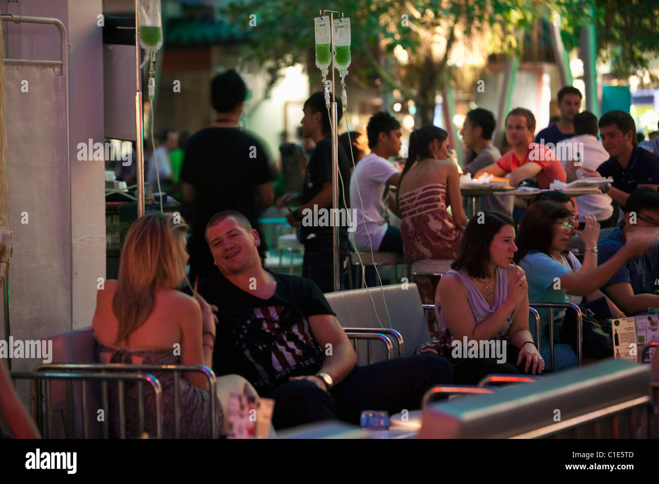 Partygänger trinken Getränke aus tropft an medizinisch angehauchte Bar - Klinik. Clarke Quay, Singapur Stockfoto