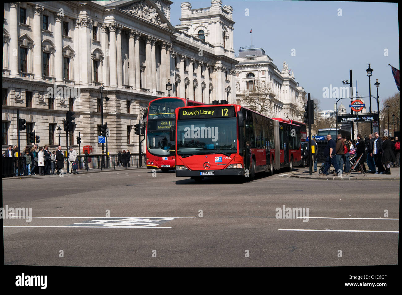 Ein Gelenkbus weitergegeben u-Bahn-Station Westminster, wie es Parliament Street, biegen links in Richtung Westminster Bridge verlässt Stockfoto