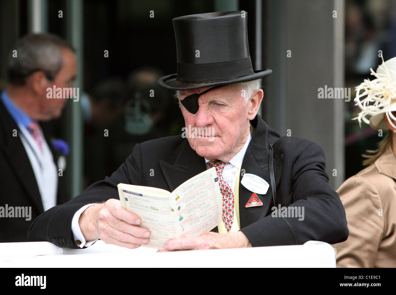 Mann in Hut und Augenklappe lesen eine Racing-Form, Ascot, Großbritannien Stockfoto