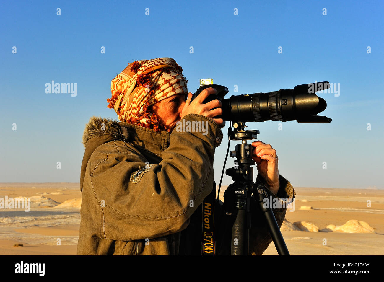 Frau Fotograf fotografiere Sanddünen mit einer Kamera auf einem Stativ in der Weissen Wüste National Park, westlich von Ägypten Stockfoto