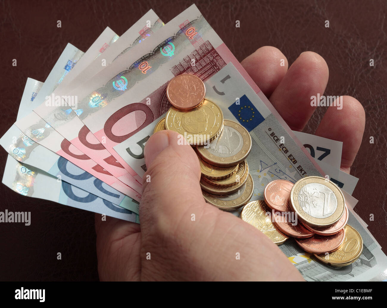 Handvoll der Euro-Euro-Banknoten und Euro-Münzen. Stockfoto