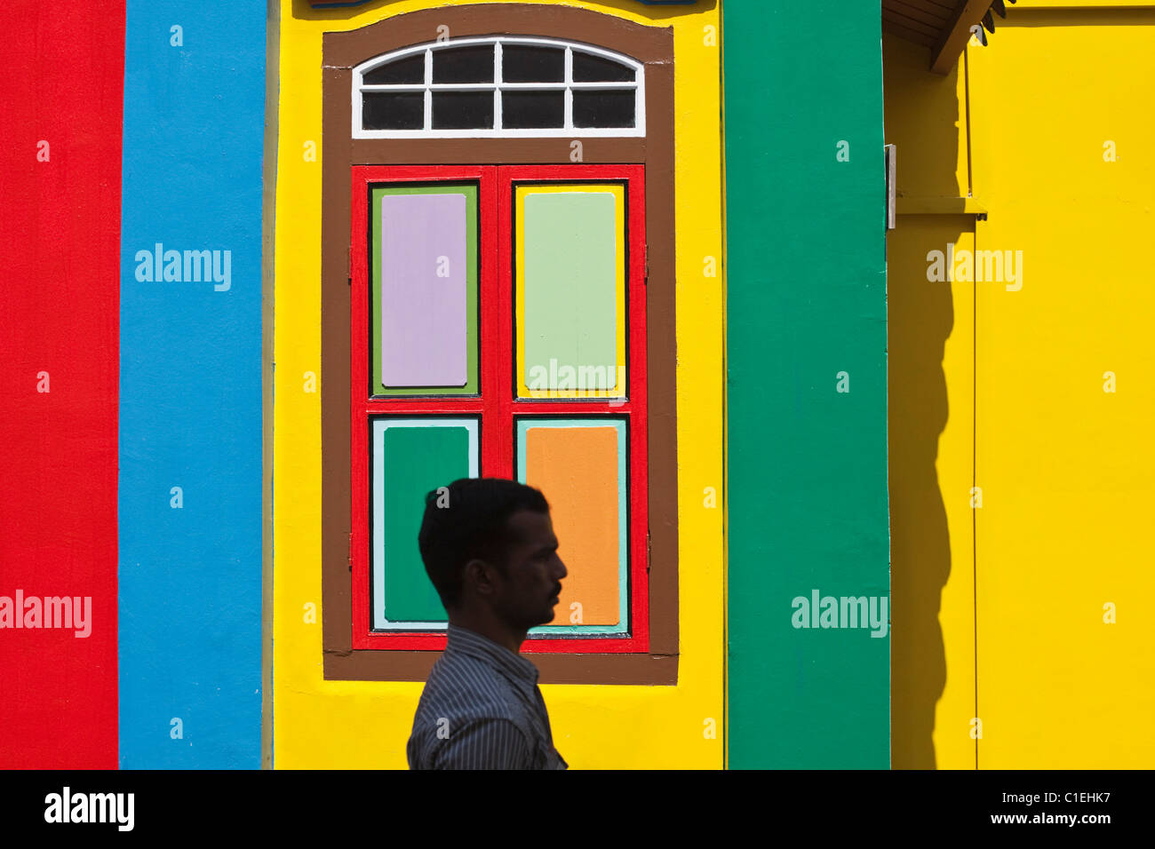 Mann zu Fuß vorbei an einem farbenfrohen denkmalgeschützten Gebäude in Little India, Singapur Stockfoto