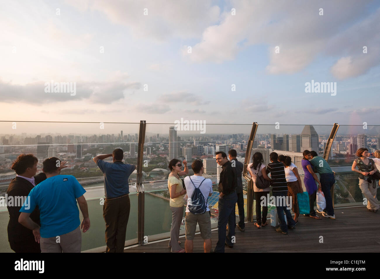 Besucher blicken auf die Skyline von Singapur von der Aussichtsplattform des Marina Bay Sands SkyPark.  Marina Bay, Singapur Stockfoto