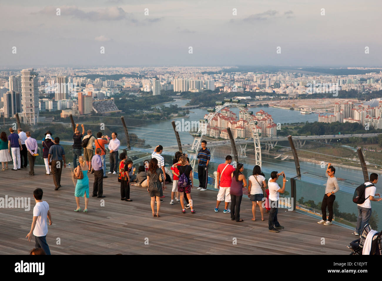 Besucher blicken auf die Skyline von Singapur von Aussichtsplattform des Marina Bay Sands SkyPark.  Marina Bay, Singapur Stockfoto