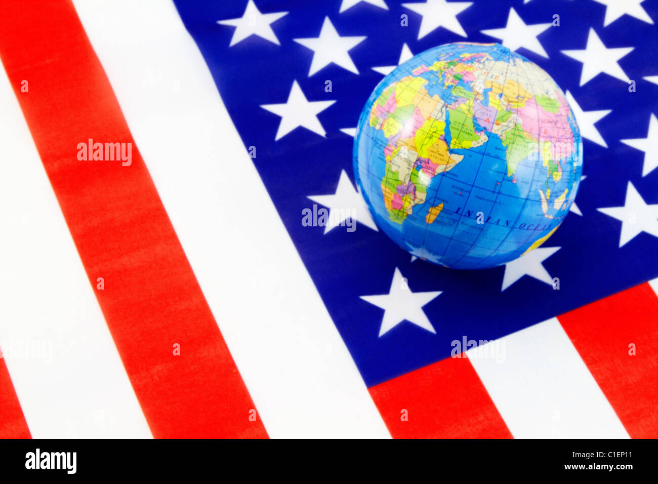 Eine Weltkugel befindet sich auf der traditionellen rot, weiß und Blau amerikanische Flagge Amerikas integrale weltweite Engagement widerspiegelt. Stockfoto