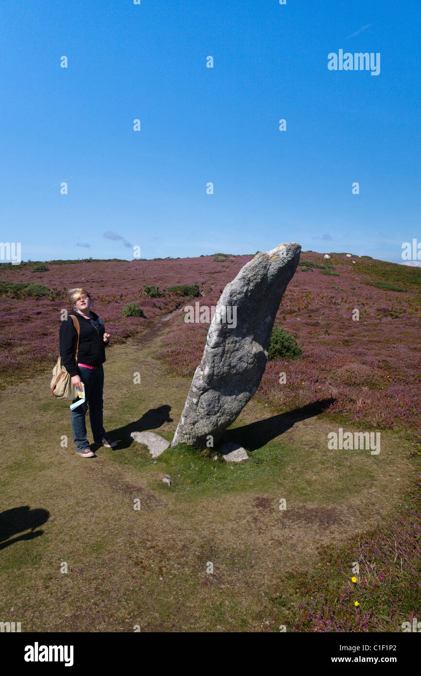 Teenager-Mädchen stand neben der Bronzezeit Steins bekannt als Greis Gugh, St Agnes Isles of Scilly Stockfoto