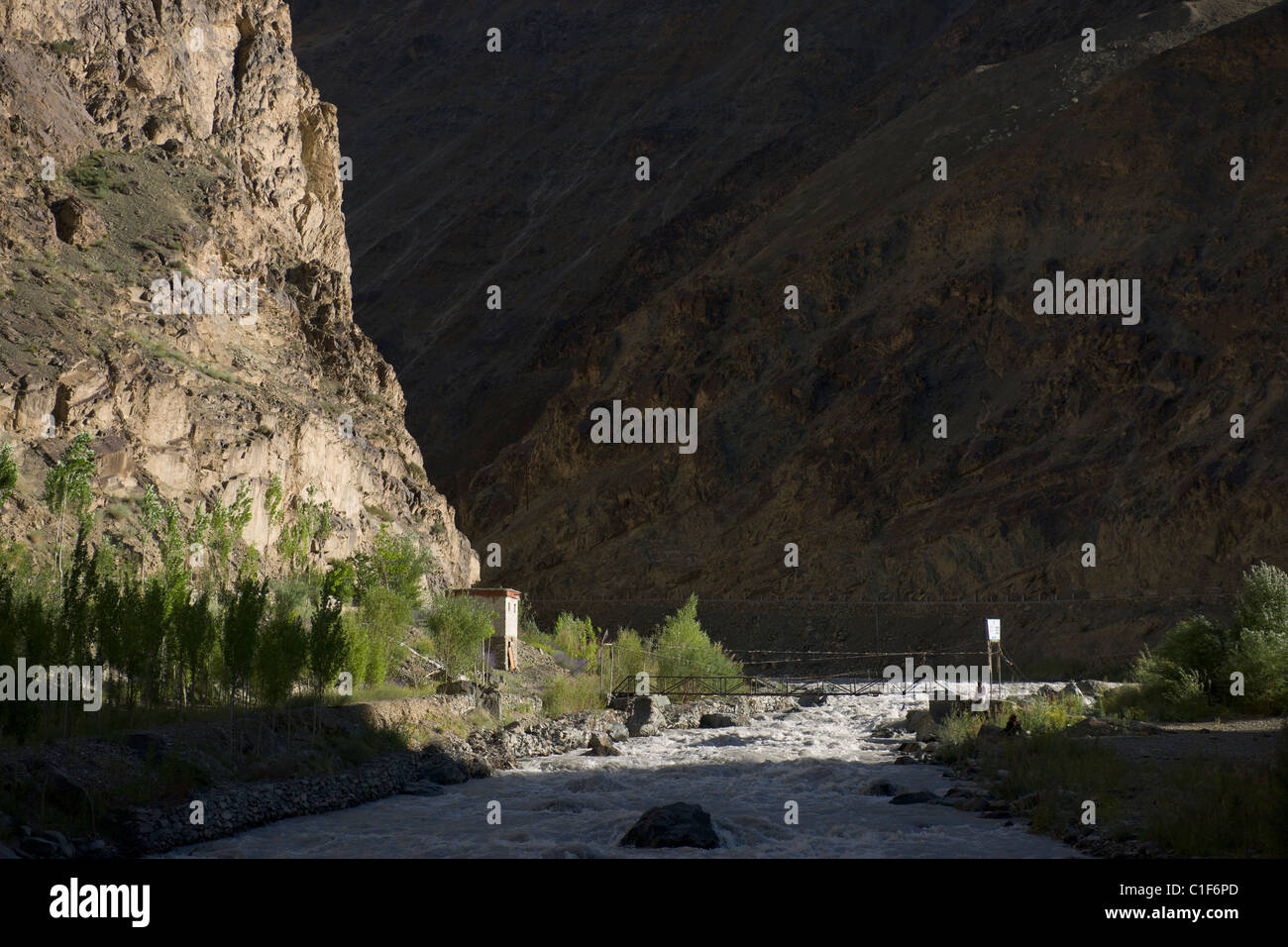 Tourist ein Buch neben einer Hängebrücke in einer tiefen Schlucht auf der Autobahn Srinagar-Leh (Ladakh) Jammu & Kaschmir, Indien Stockfoto