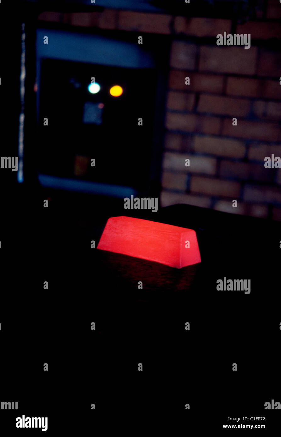 Eine glühende Bar Gold kühlt langsam nach der Entnahme aus einem Barren-Form, die in einem Ofen bei einer Goldmine Johannesburg in Südafrika war. Stockfoto