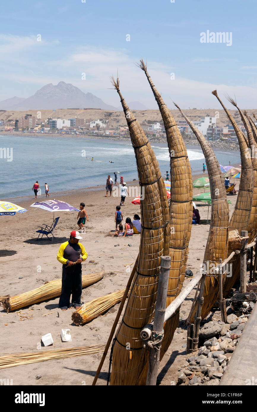 Huanchaco Beach in der Nähe von Trujillo, Peru, mit Caballitos de Totora und Urlauber Stockfoto