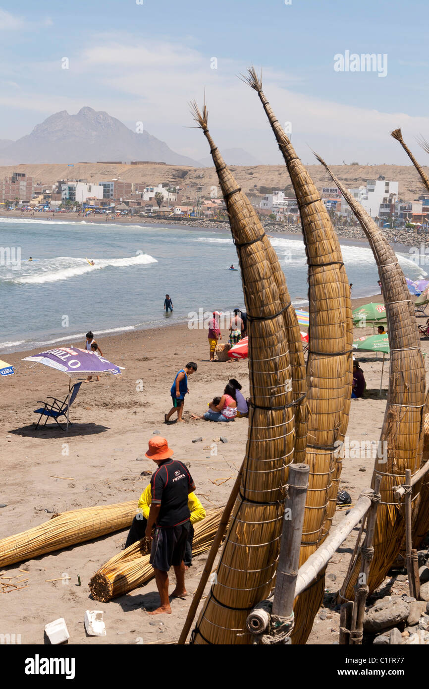 Huanchaco Beach in der Nähe von Trujillo, Peru, mit Caballitos de Totora und Urlauber Stockfoto