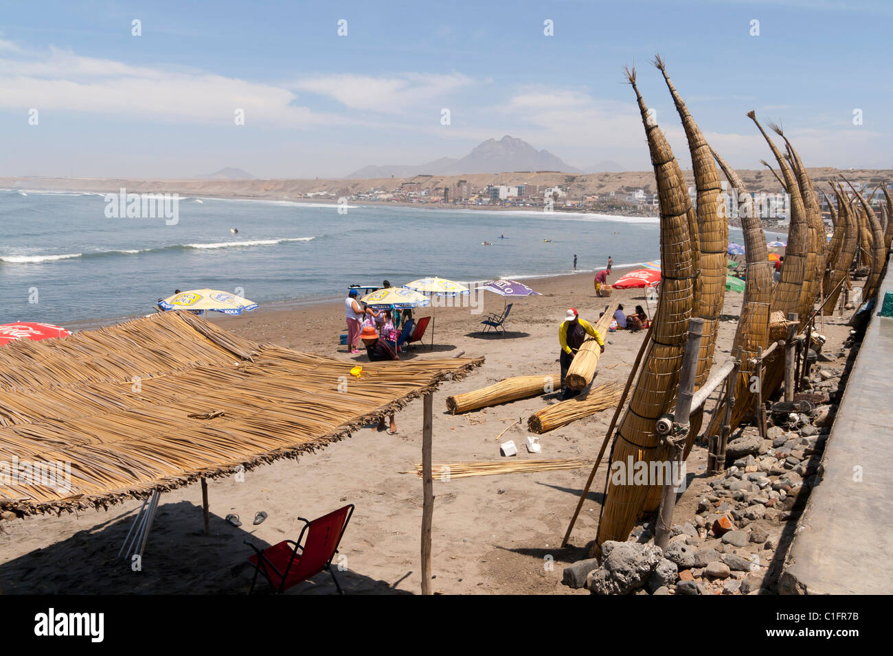 Huanchaco Beach in der Nähe von Trujillo, Peru, mit Caballitos de Totora und Urlauber Stockfoto