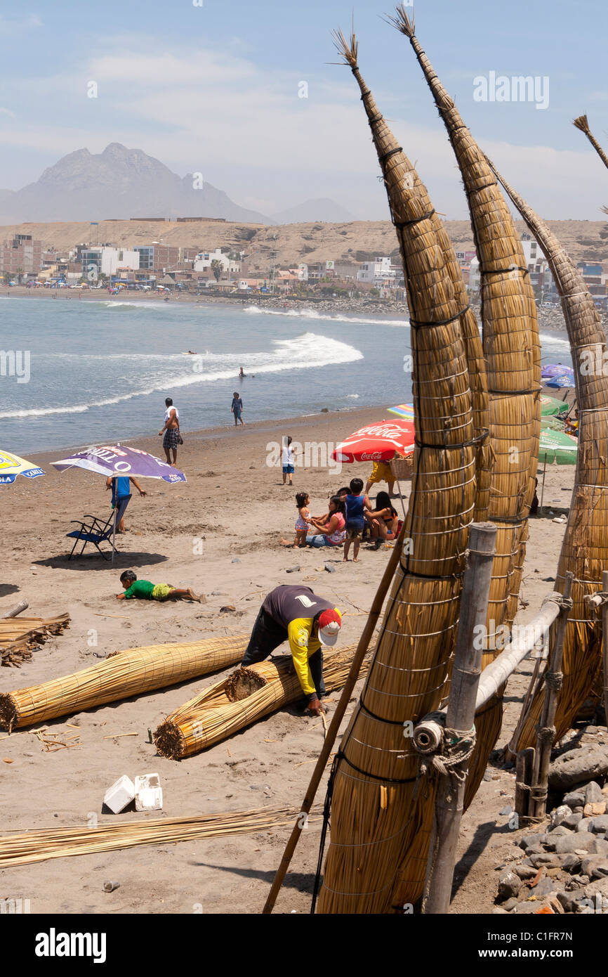 Huanchaco Beach in der Nähe von Trujillo, Peru, mit Caballitos de Totora und Urlauber Stockfoto