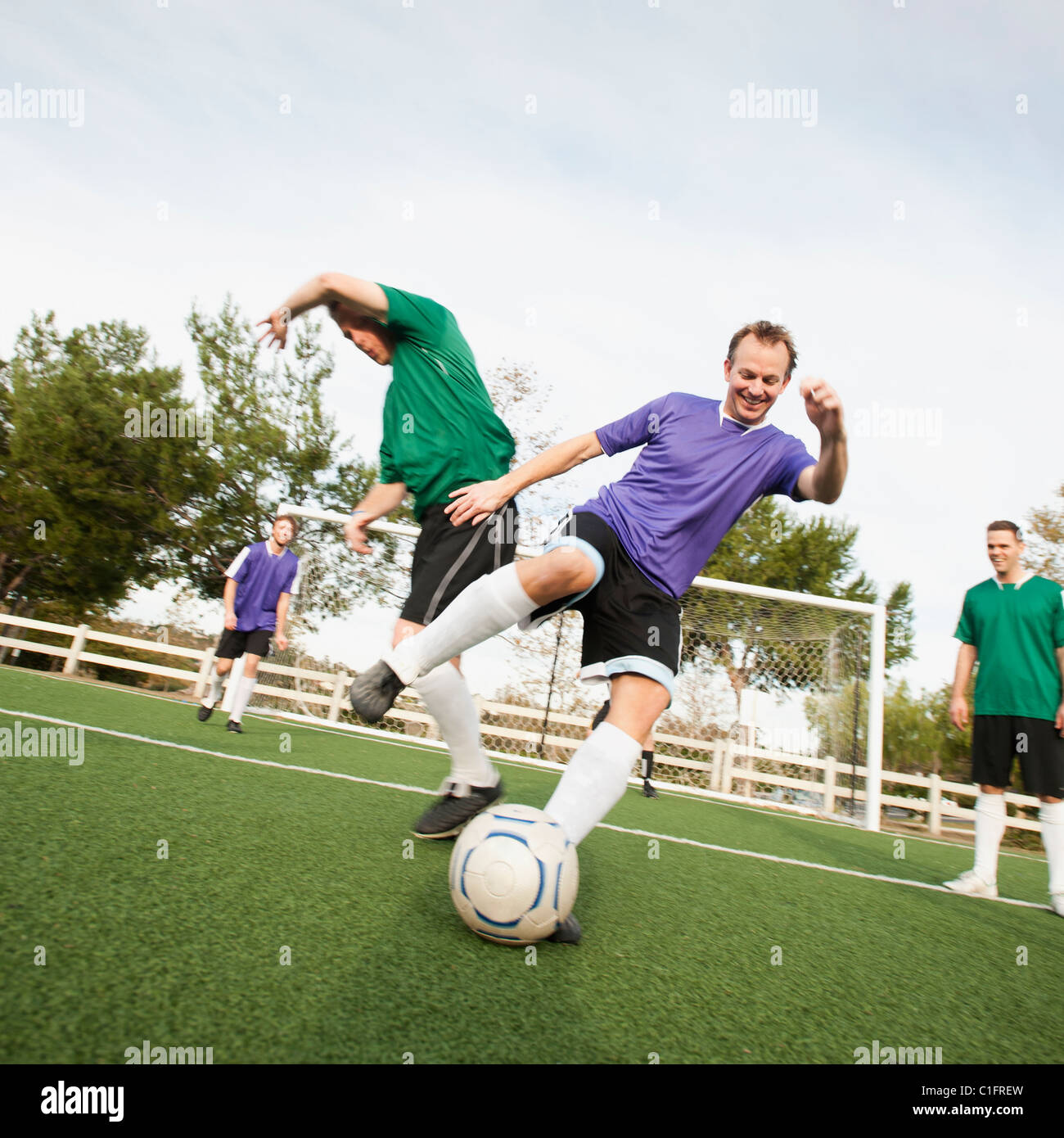 Männer spielen Fußball auf Fußballplatz Stockfoto