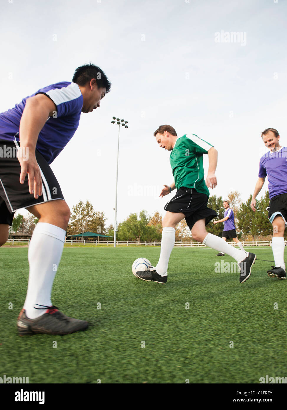 Männer spielen Fußball auf Fußballplatz Stockfoto