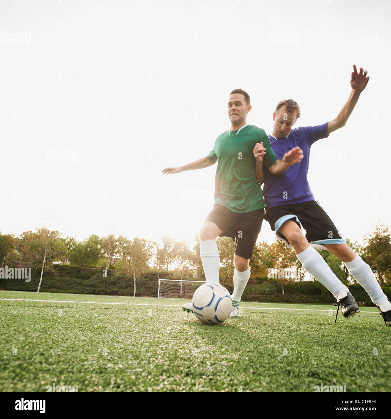 Männer spielen Fußball auf Fußballplatz Stockfoto