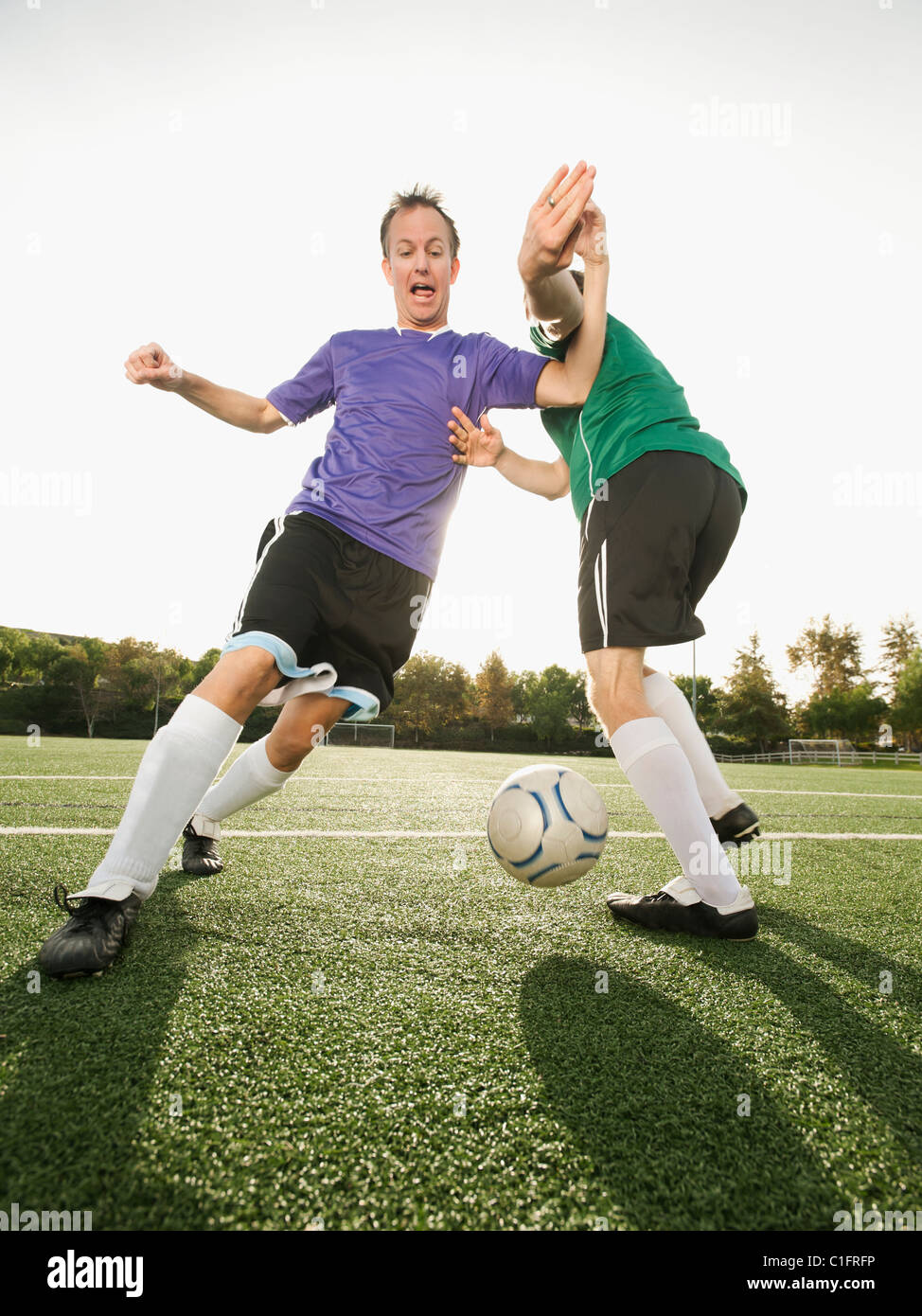 Männer spielen Fußball auf Fußballplatz Stockfoto