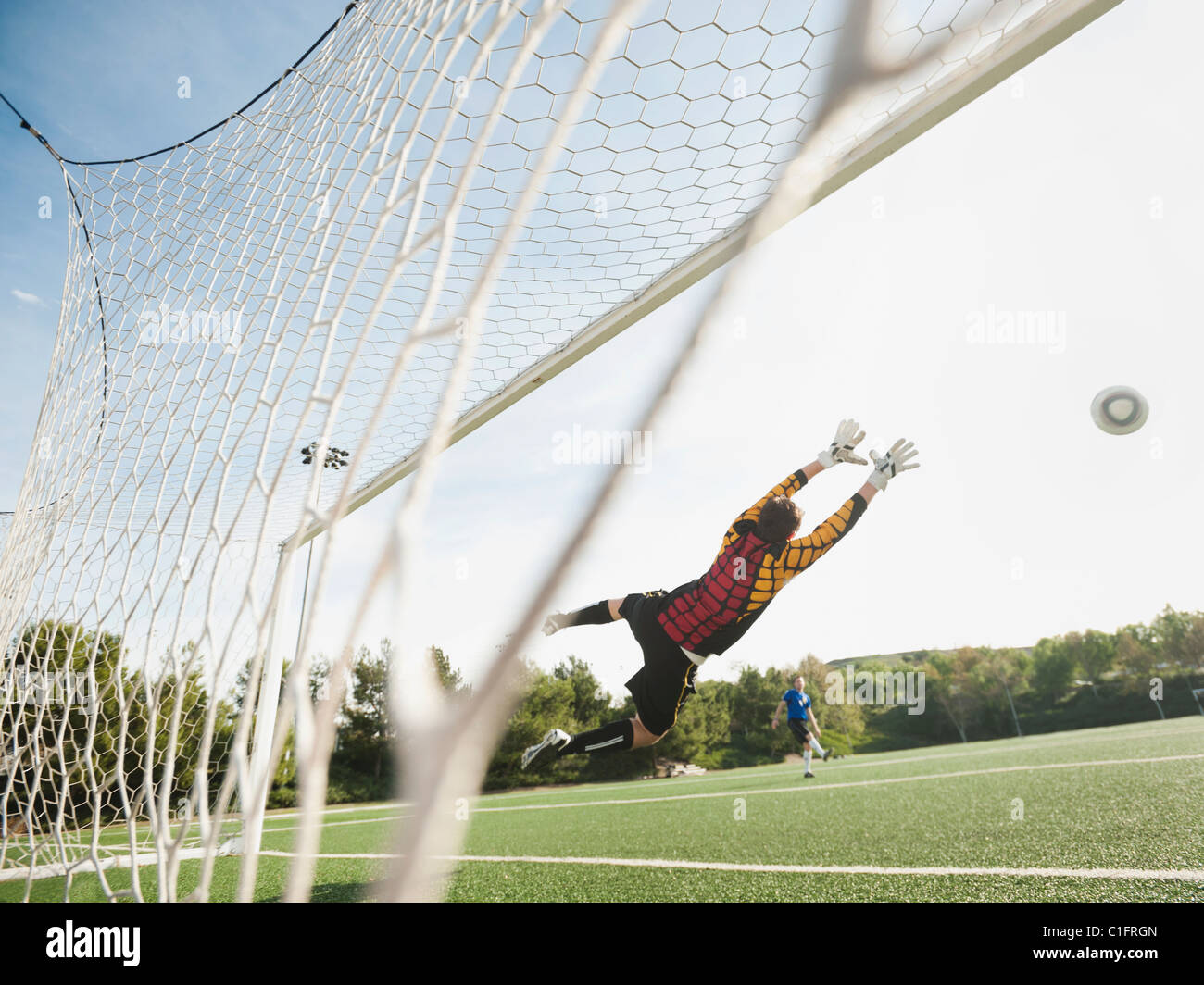 Gemischte Rassen Torhüter in der Luft schützen Ziel Stockfoto
