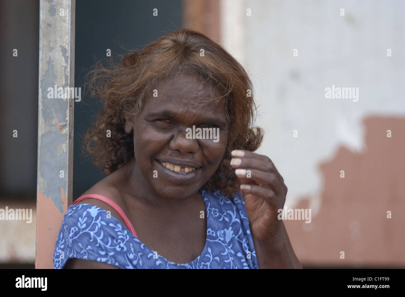 Lächelnd Aboriginefrau auf der vorderen Veranda eines alten Hause sitzt, Western Australia. Stockfoto