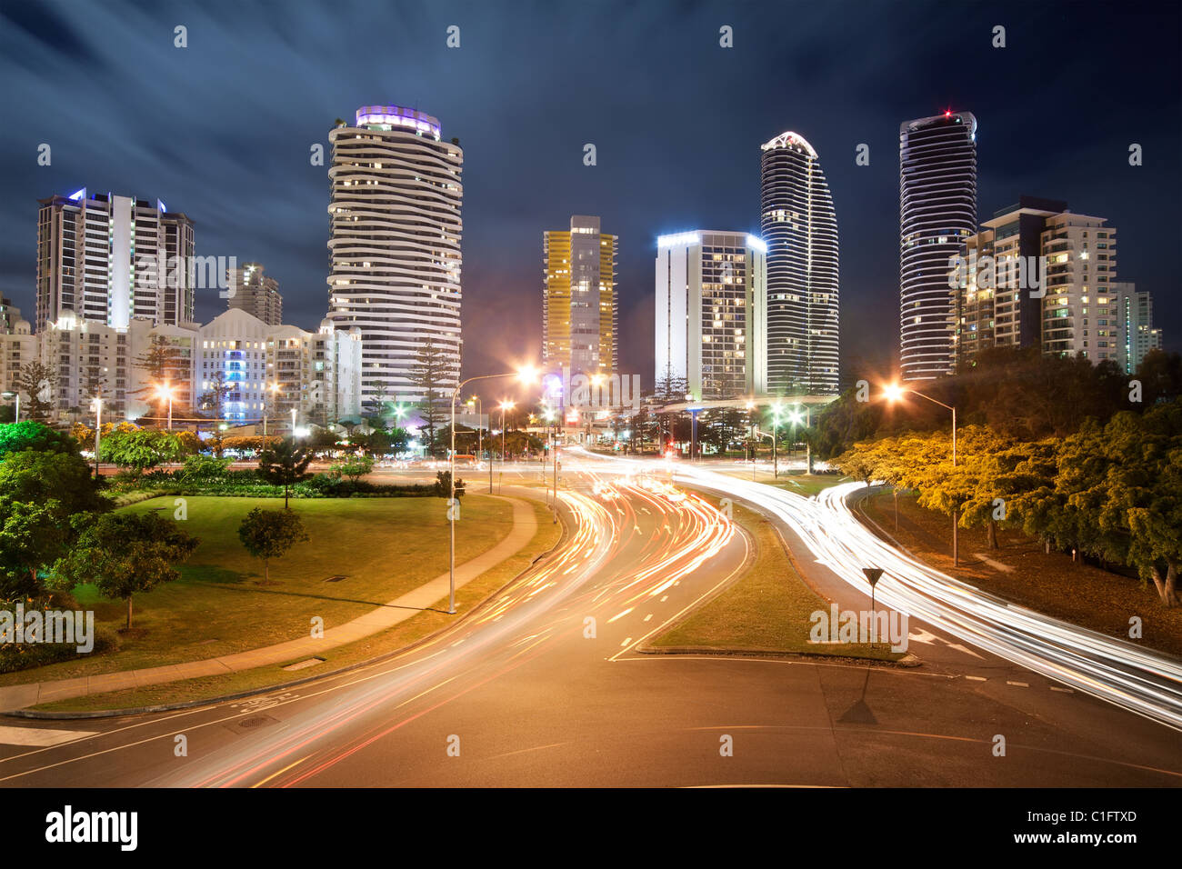 Moderne australische Stadt bei Nacht mit bewegte Wolken im Hintergrund und Verkehr Autolichter im Vordergrund (Broadbeach, Gold Coast, Queensland Stockfoto