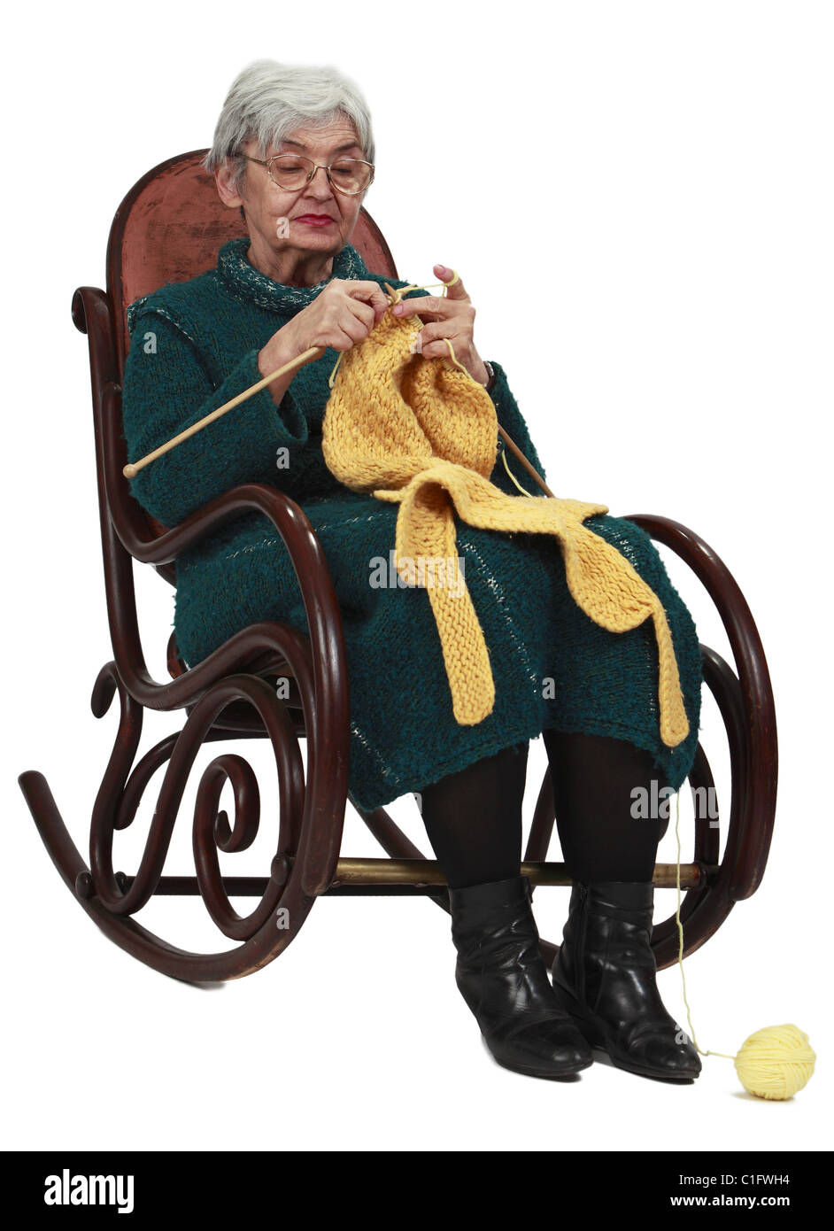 Bild einer alten Frau sitzen auf einer Wippe und stricken, vor einem weißen Hintergrund isoliert. Stockfoto