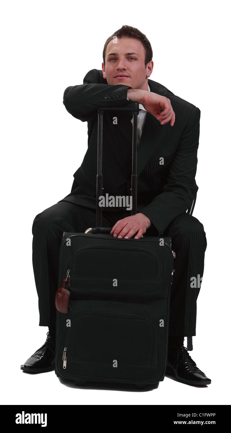 Müde und gelangweilt Geschäftsmann mit seinem Koffer isoliert auf einem weißen Hintergrund. Stockfoto