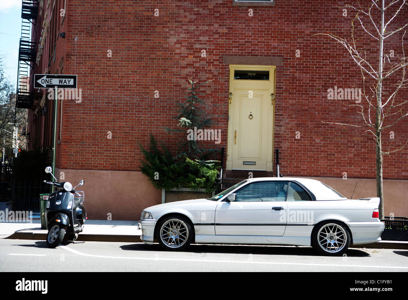 Cabrio BMW und einem Vespa-Roller in der Weststadt Dorf New York geparkt Stockfoto