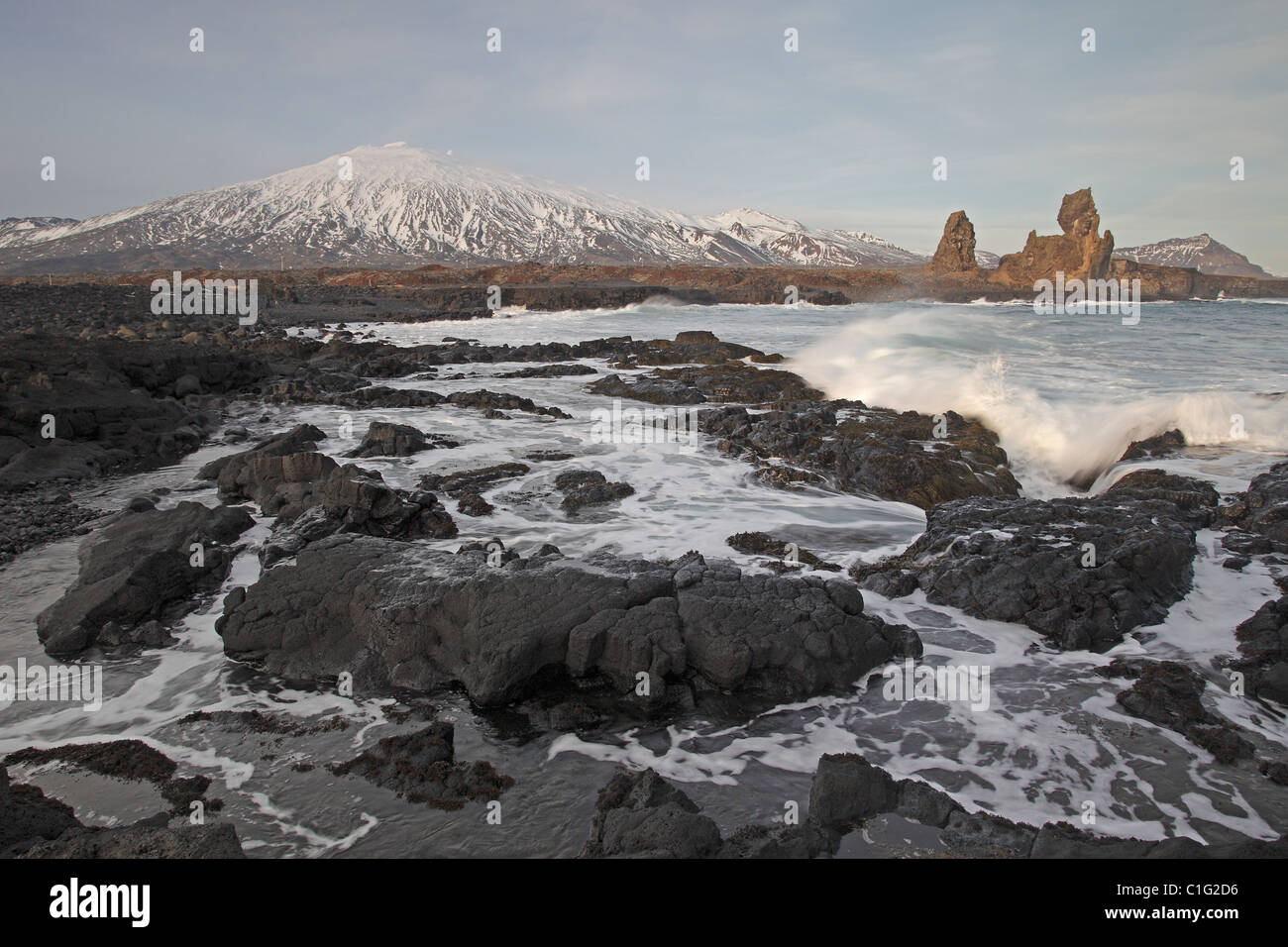 Meer-Stacks in Island mit dem Schnee bedeckt Snaefellsjökull Vulkan im Hintergrund Stockfoto