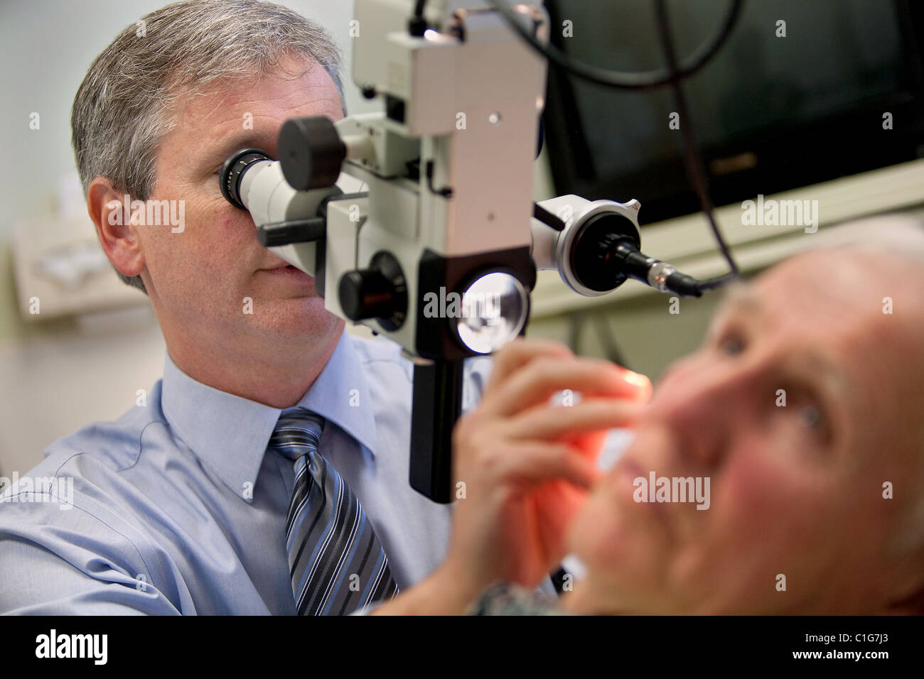 Ein Arzt fügt ein Patient ein Hörgerät. Stockfoto