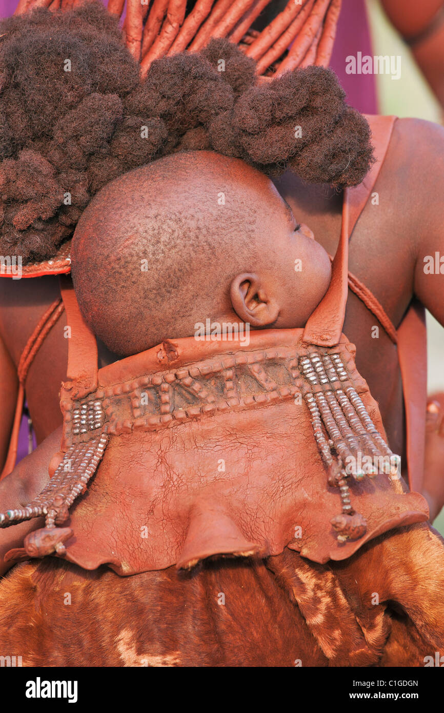 Himba-Baby im traditionellen Beutel in der Kunene Region, Namibia lebenden Stockfoto