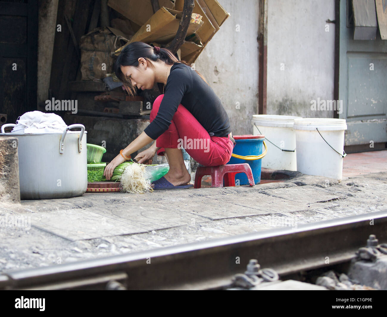 Die Lebensdauer der Bahnstrecke im Herzen von Hanoi, Vietnam. Eine Frau bereitet das Abendessen. Stockfoto