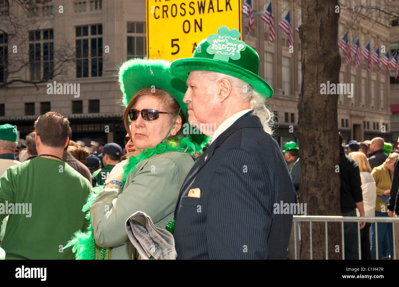 17. März 2011 - NYC: Paar beobachtete St. Patricks Day Parade in Fifth Avenue Menschenmenge, Herr und Dame mit grünen Hüten. Stockfoto